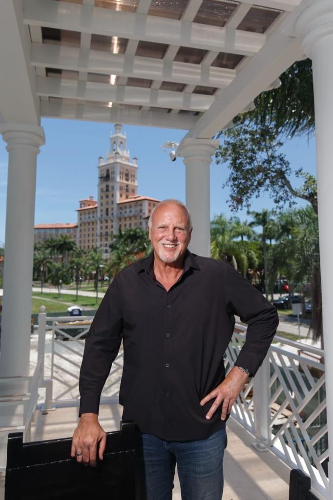 Willy A. Bermello at the colonnade with the Coral Gables skyline
